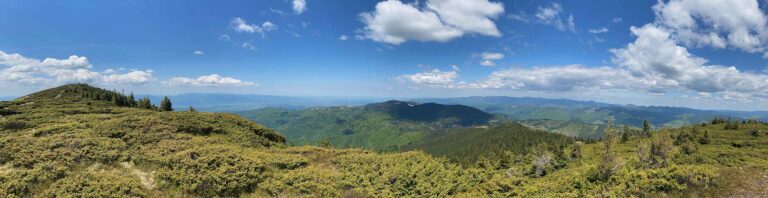 Panoramablick auf afrikanische Berge, grüne Hügel und blauer Himmel, ideal für Safari und Naturreisen.