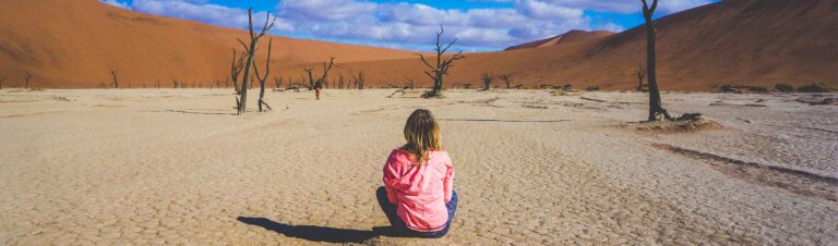 Bewegende Szene in der Namib-Wüste, Zagreb-Wüstenlandschaft mit versteinerten Bäumen, inklusive Kind.