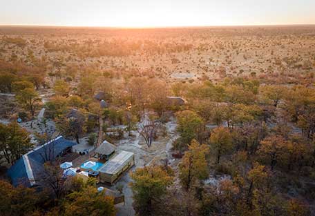 Ein Zeltlager in der afrikanischen Wildnis bei Sonnenuntergang.