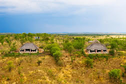 Zwei Safari-Lodges in der Natur Afrikas, umgeben von grünen Wäldern und weiten Savannen.