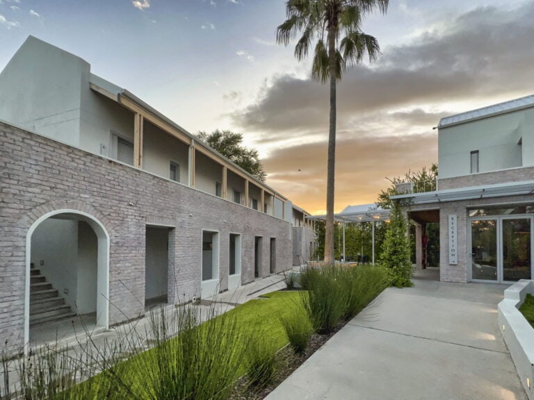 Moderne Hotelanlage in Afrika mit tropischem Garten bei Sonnenuntergang.