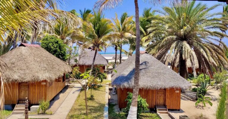 Attraktive Strandhütten in Afrika, tropischer Strand, Palmen und Sonne.