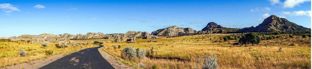 Panorama einer afrikanischen Savanne mit Straßen und Felsen, ideal für Safari und Naturreisen.