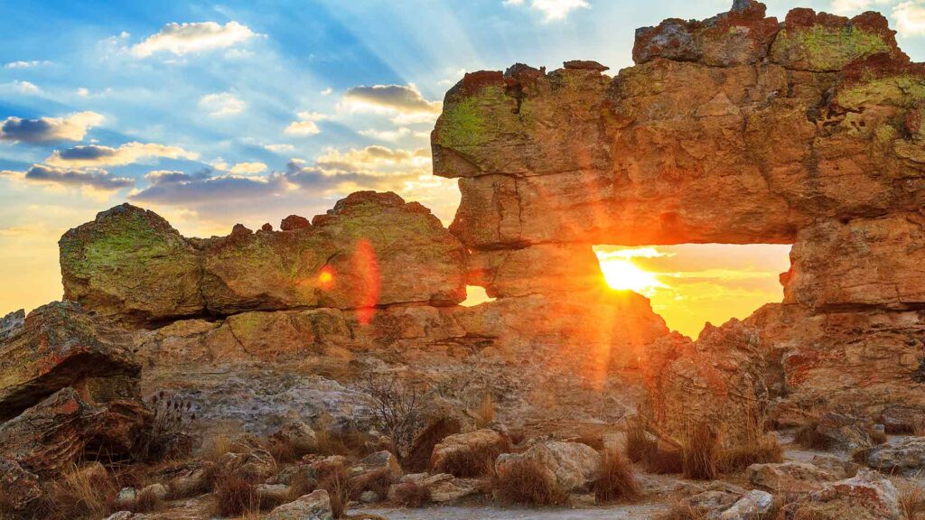 Detailliertes Bild einer afrikanischen Naturlandschaft mit Felsen, Sonnenuntergang und Himmel, ideal für Reise- und Abenteuer-Webseiten.