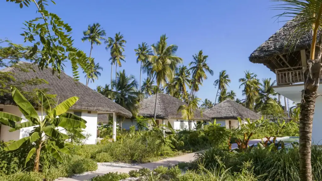 Paradiesische Strandhütten mit Palmen.
