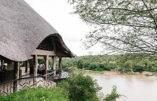 Luxushütte mit Blick auf den Fluss in Afrika, perfekte Safari-Unterkunft, afrikanisches Reiseerlebnis.