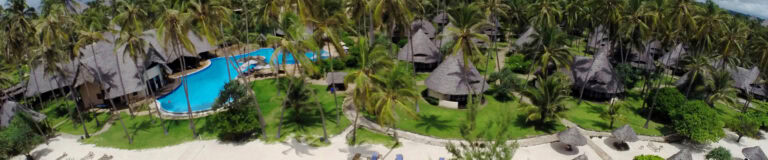 Klimatisierte Bungalows unter Palmen am afrikanischen Strand.