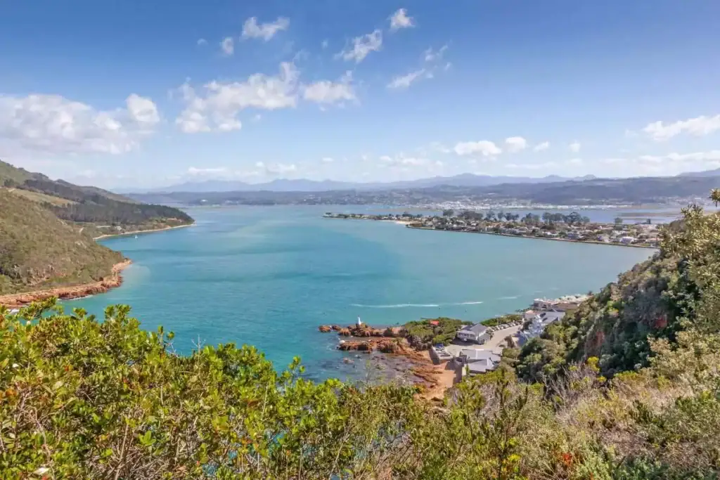 Herrlicher Blick auf den Lake Rotorua, Neuseeland, mit grünen Hügeln, blauer Wasserfläche und Stadt im Hintergrund | Beliebter Ort für Afrika Abenteuer und Naturerkundungen.