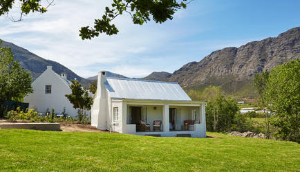Gemütliches afrikanisches Landhaus inmitten grüner Natur mit Bergblick in Namibia.