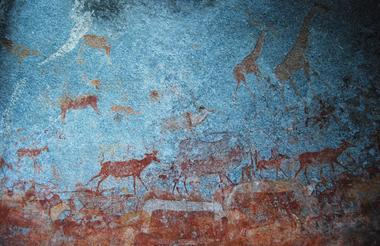 Höhlenmalereien mit afrikanischen Tieren in einer Felswand, prähistorische Kunst.