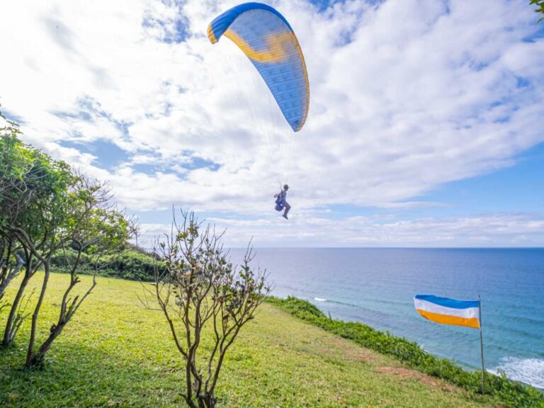 Alt Text: Paragliding über Afrikas Küste mit blauen Himmel und Meeresblick.