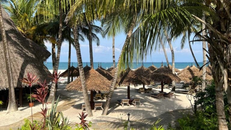 Alt: Maledivische Strandhütten mit Palmen am weißen Sandstrand, tropisches Urlaubsparadies.