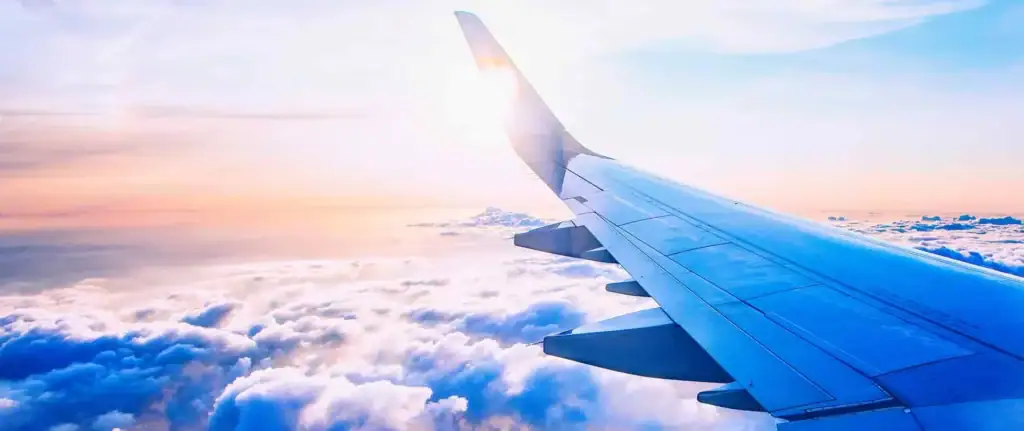 Flugzeugflügel über Wolken bei Sonnenuntergang, Afrika Reisetraum.