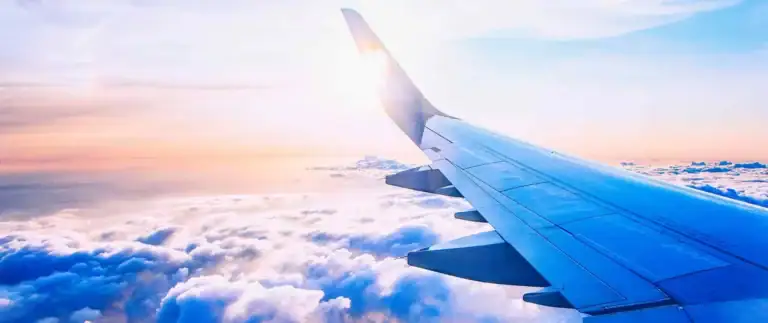 Flugzeugflügel über Wolken bei Sonnenuntergang, Afrika Reisetraum.