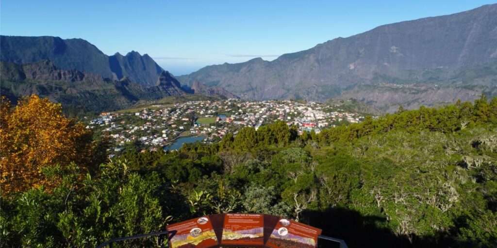 Alt Text: Blick über eine afrikanische Bergstadt mit grünen Hügeln und Bergen im Hintergrund.