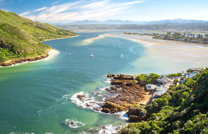 Breathtaking view of a Norwegian fjord with blue waters, lush greenery, and mountains in the background.
