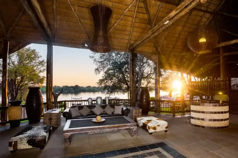Afrikanische Lodge mit Blick auf Fluss, Sonnenuntergang, Safari, Natur, Urlaub.
