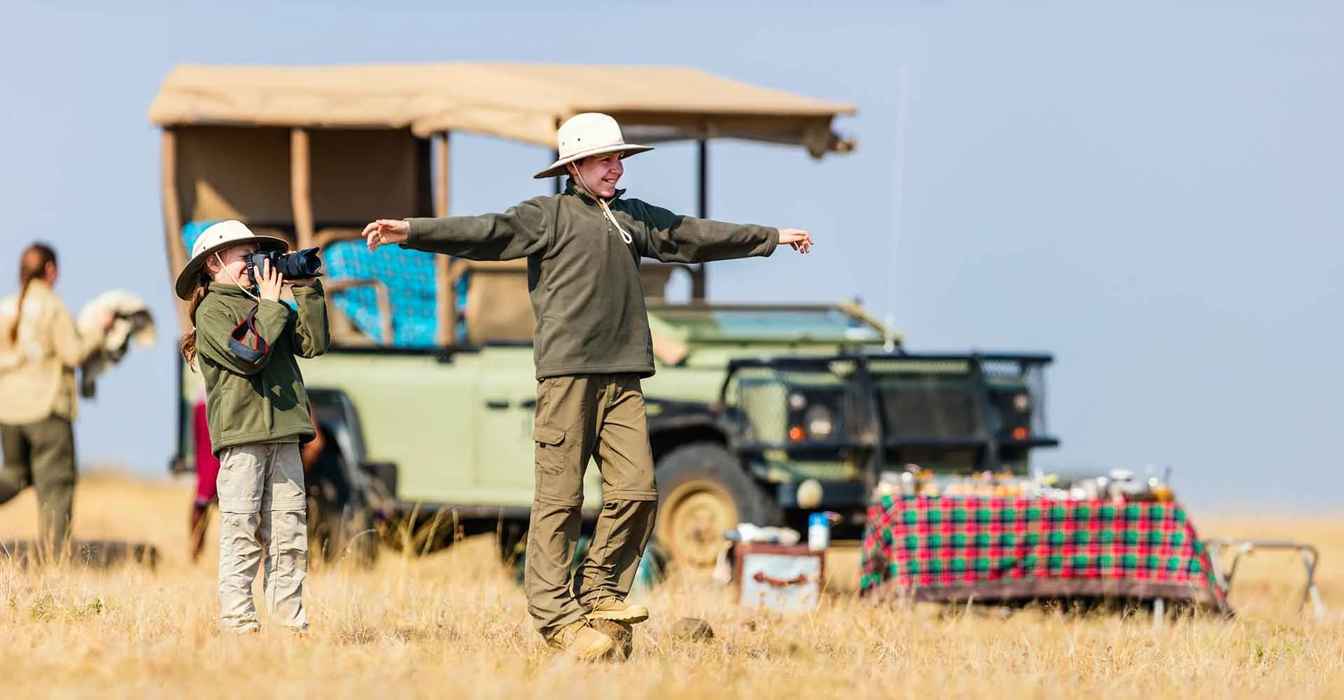 Junge Safari-Teilnehmer mit Fernglas in afrischer Savanne, Tierbeobachtung, Safari-Erlebnis.