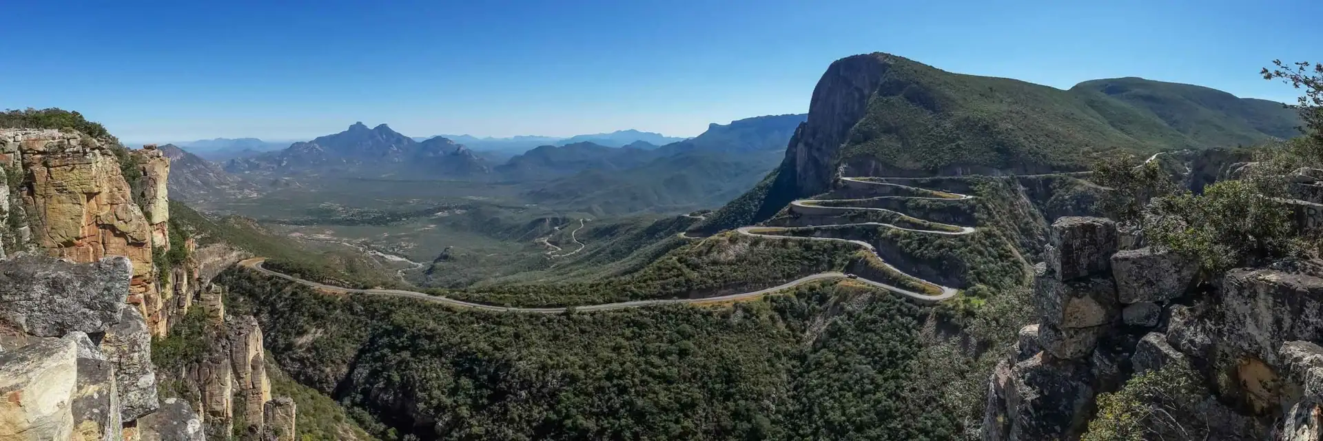 Beeindruckendes Bergpanorama in Afrika mit kurviger Straße und grüner Natur.