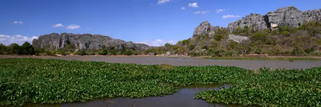 Erleben Sie die beeindruckende Landschaft im Malawi-See, mit grünem Wasser und Felsen im Hintergrund, perfektes Afrika-Reiseziel.