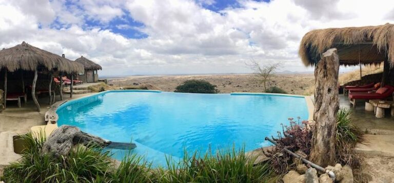 Infinity Pool mit Blick auf die afrikanische Landschaft bei Maasai Lodge.