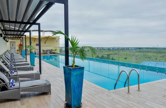 Poolbereich mit Liegestühlen und Blick auf die Landschaft.
