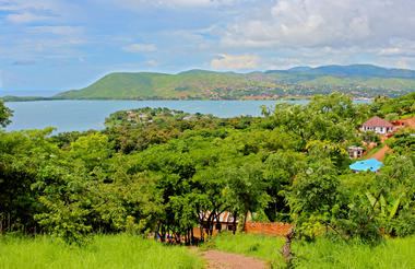 Landschaft im Gombe Stream National Park mit See und Bergen.