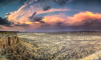Sonnenuntergang über der afrikanischen Wüste, weite Steppen und Felsen.