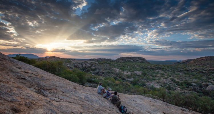 Sonnenuntergang über den afrikanischen Bergen mit Safari-Abenteurern.